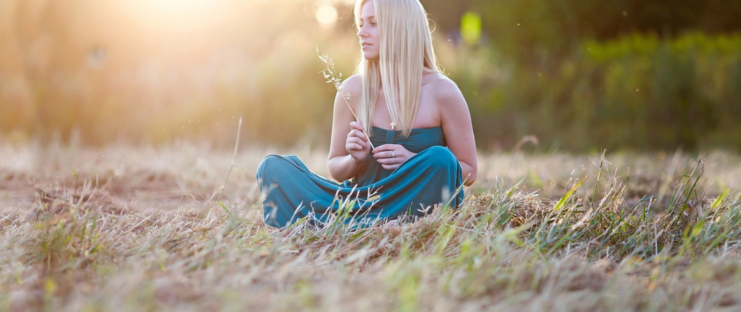 Очаровательная блондинка голая сидит на траве
