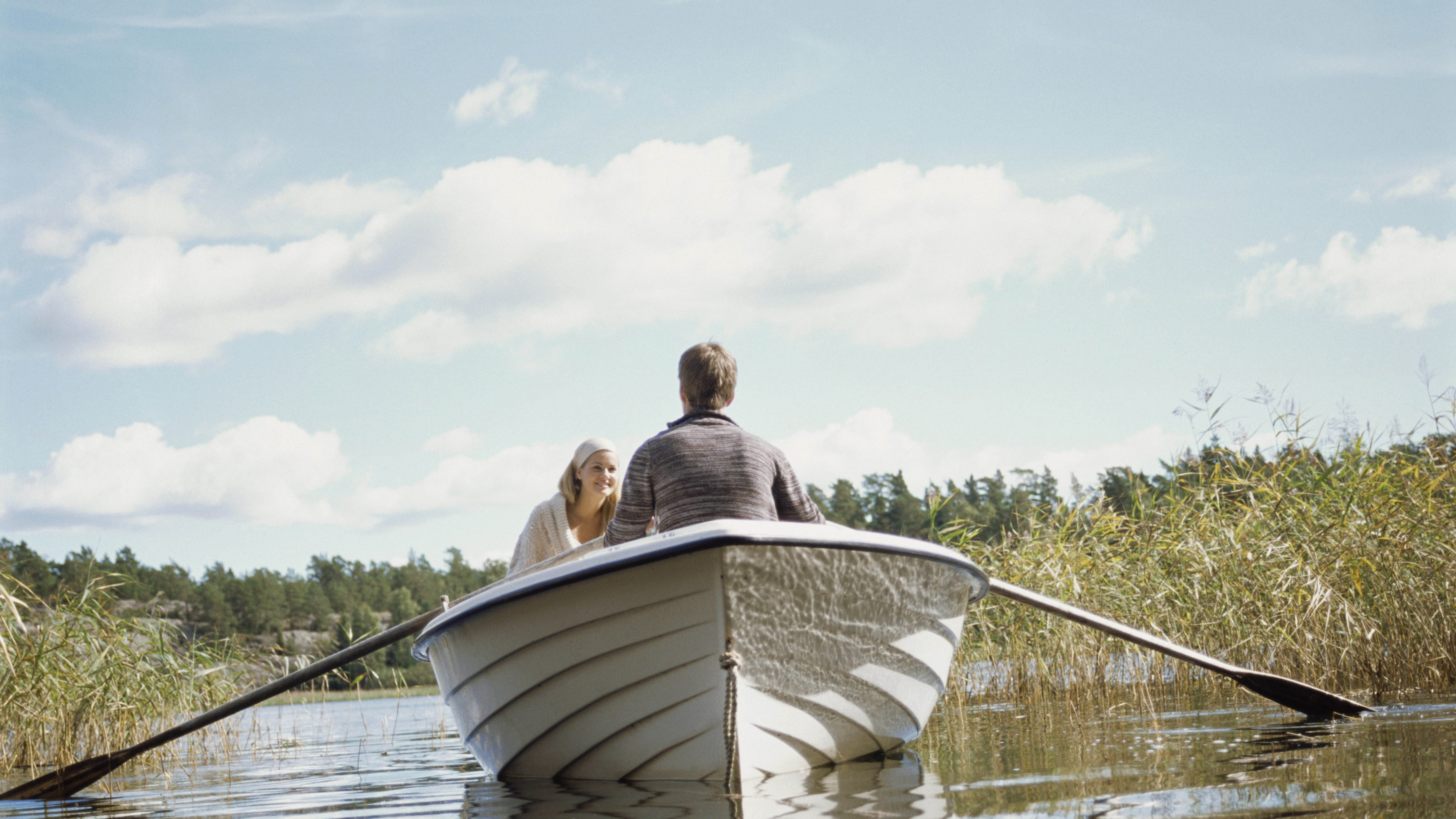 Двое подошли к реке лодка. Человек в лодке. Лодка на озере. Отдых на природе. Лодка плывет по озеру.