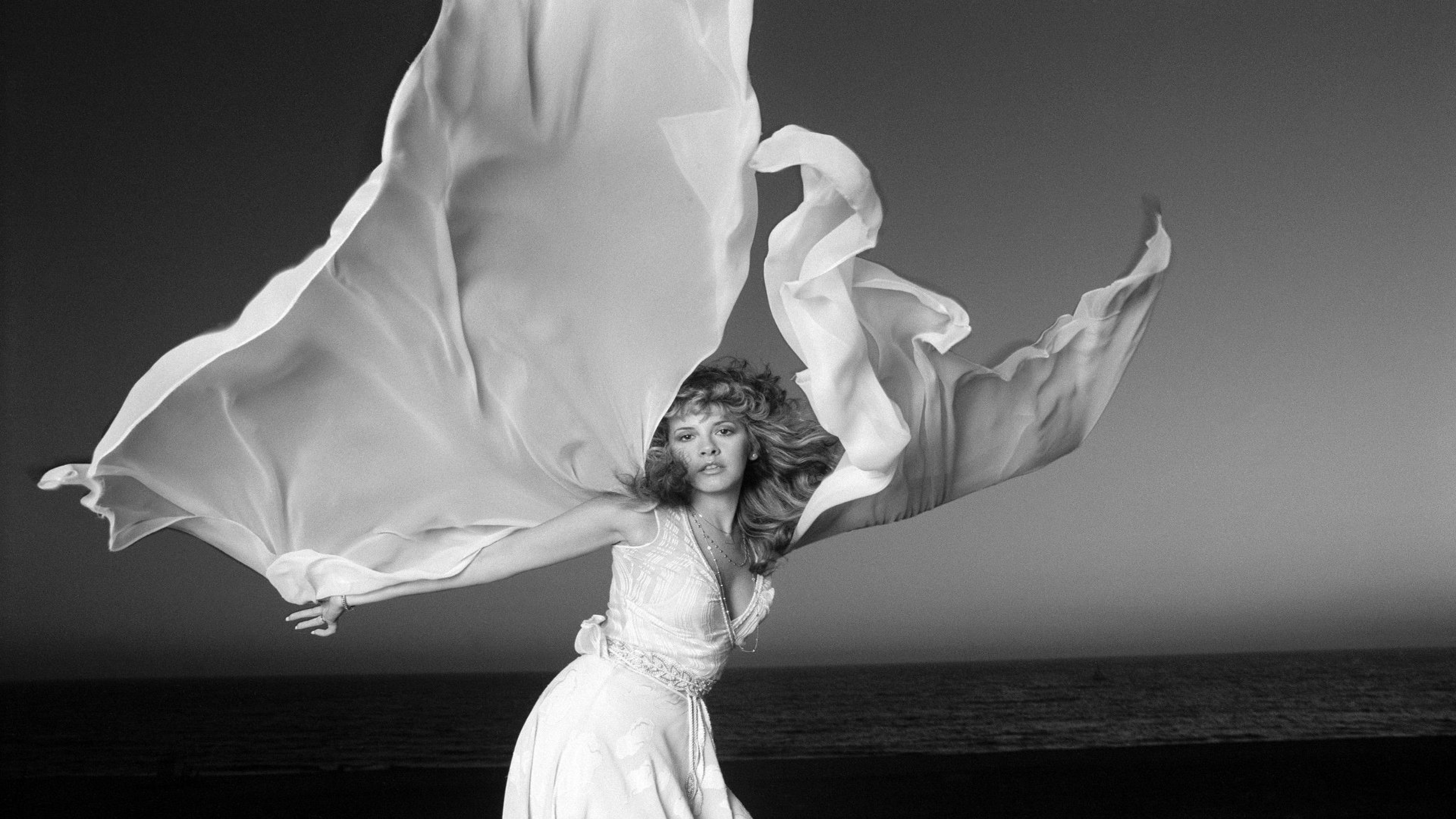 Она танцует в белом платье смотрит тайно. Stevie Nicks. Stevie Nicks. Фото. Stevie Nicks 1989. Девушка в белом платье танцует.