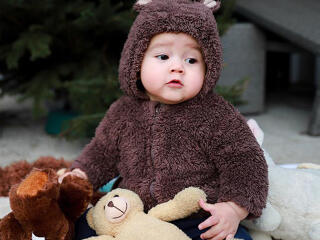 Cute Baby In Brown Woolen with Toys wallpaper