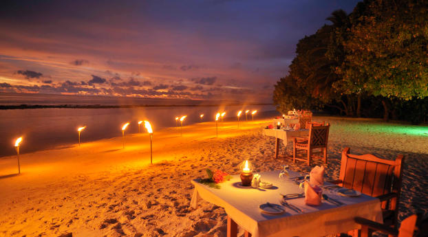 Dining on the Beach at Night in the Maldives Ocean Wallpaper
