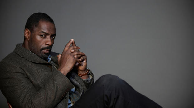 Idris Elba On Chair Pic Wallpaper 1360x768 Resolution